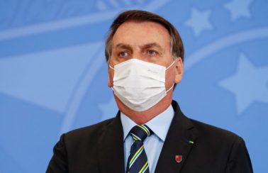 Usando máscara, Bolsonaro sanciona lei que facilita compra de vacinas contra Covid-19